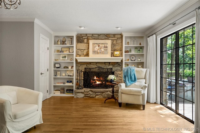 6530 E 106th St, Tulsa, OK 74133 - living area featuring a stone fireplace, wood finished floors, crown molding, built in shelves, and a textured ceiling