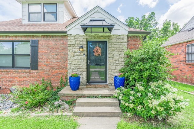 2648 E 2nd St, Tulsa, OK 74104 - property entrance with stone siding, roof with shingles, and brick siding