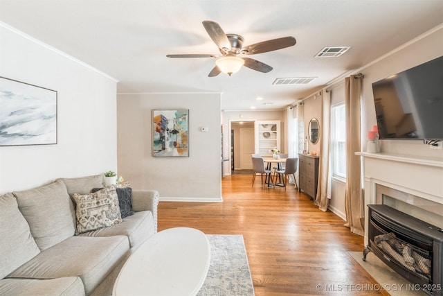 2648 E 2nd St, Tulsa, OK 74104 - living area featuring a ceiling fan, light wood-style floors, and ornamental molding