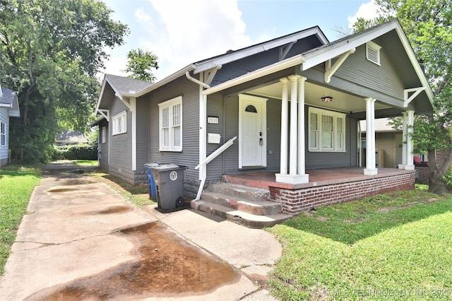 2020 E 14th St, Tulsa, OK 74104 - view of front of property featuring driveway, a porch, and a front yard