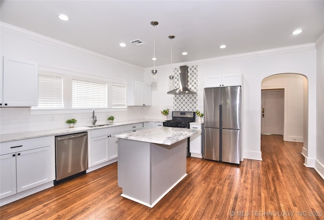 2020 E 14th St, Tulsa, OK 74104 - kitchen with appliances with stainless steel finishes, wall chimney exhaust hood, arched walkways, ornamental molding, and tasteful backsplash