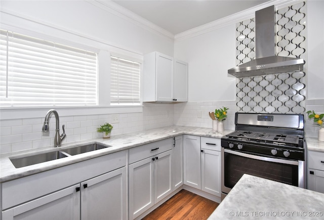 2020 E 14th St, Tulsa, OK 74104 - kitchen featuring stainless steel range with gas stovetop, wall chimney range hood, crown molding, backsplash, and wood finished floors