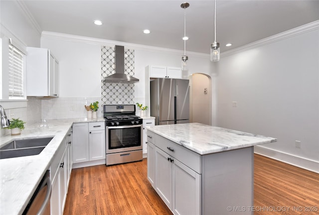 2020 E 14th St, Tulsa, OK 74104 - kitchen featuring wall chimney exhaust hood, appliances with stainless steel finishes, arched walkways, ornamental molding, and decorative backsplash