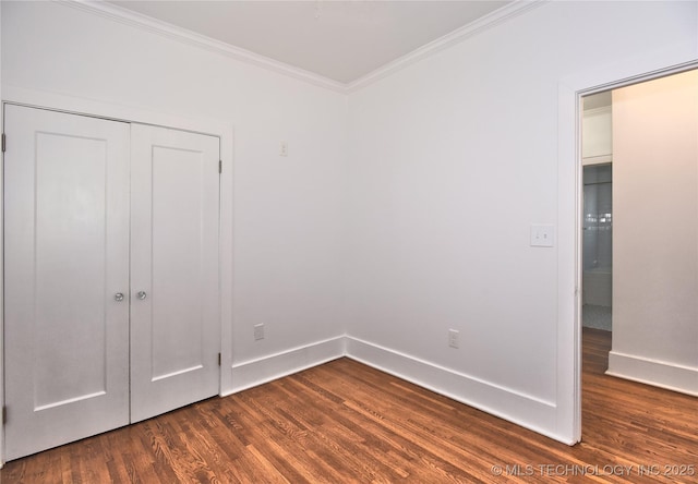 2020 E 14th St, Tulsa, OK 74104 - unfurnished bedroom with crown molding, dark wood-type flooring, and a closet