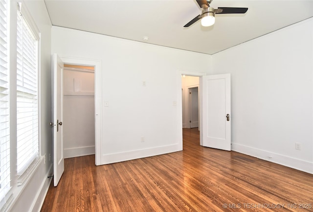 2020 E 14th St, Tulsa, OK 74104 - unfurnished bedroom with wood finished floors, a ceiling fan, and a walk in closet