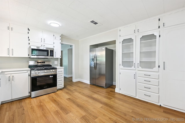 202 W Burnham Ave, Sapulpa, OK 74066 - kitchen featuring stainless steel appliances, light countertops, white cabinets, and light wood-style flooring