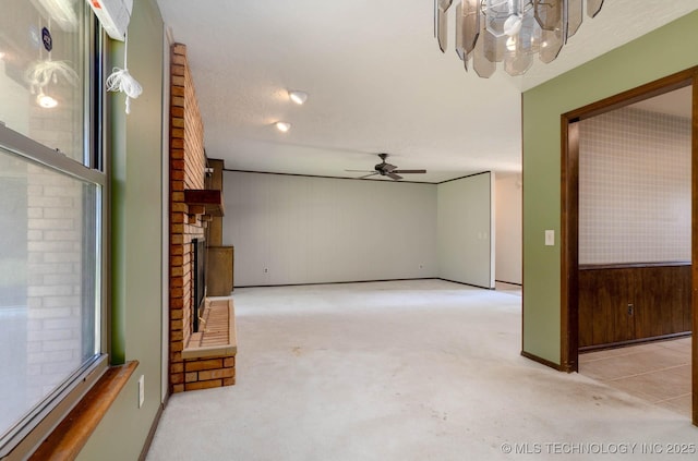 606 N Gum St, Jenks, OK 74037 - unfurnished living room featuring carpet, a brick fireplace, ceiling fan, and a chandelier