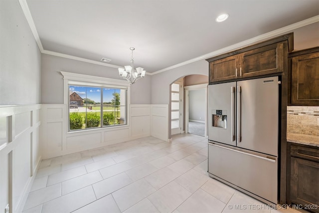 6107 E 127th St N, Collinsville, OK 74021 - kitchen with high quality fridge, arched walkways, dark brown cabinets, a chandelier, and wainscoting