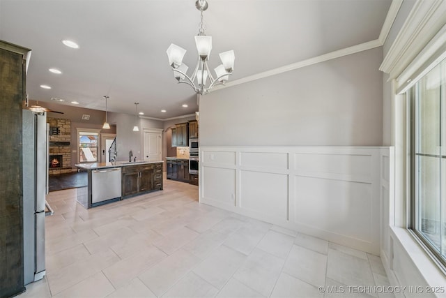 6107 E 127th St N, Collinsville, OK 74021 - kitchen featuring appliances with stainless steel finishes, crown molding, dark brown cabinetry, a center island with sink, and recessed lighting