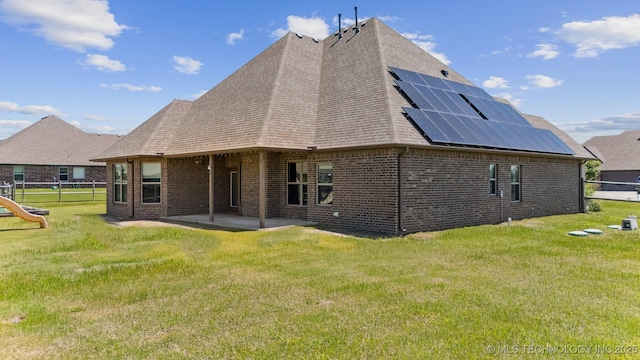 6107 E 127th St N, Collinsville, OK 74021 - rear view of property featuring solar panels, a patio area, brick siding, and a shingled roof