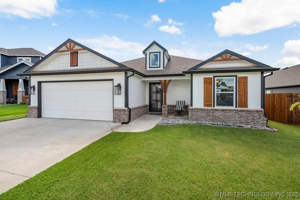 craftsman-style house with brick siding, driveway, and an attached garage