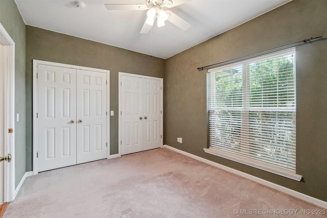 1701 N Skinner Ave, Drumright, OK 74030 - unfurnished bedroom featuring multiple closets, carpet floors, and ceiling fan