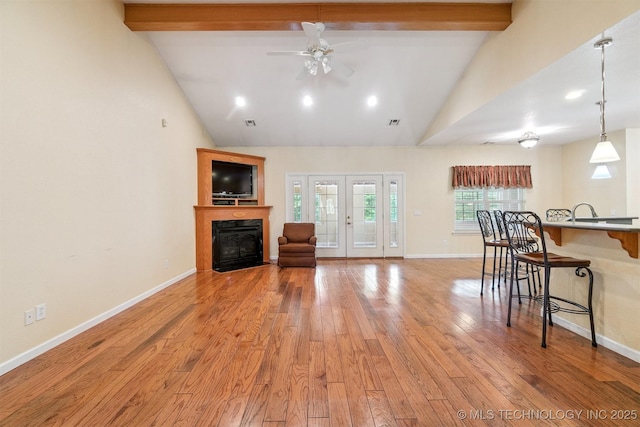 1701 N Skinner Ave, Drumright, OK 74030 - living area with ceiling fan, light wood finished floors, beamed ceiling, a glass covered fireplace, and high vaulted ceiling
