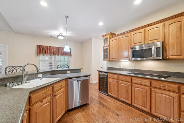 1701 N Skinner Ave, Drumright, OK 74030 - kitchen featuring stainless steel appliances, wine cooler, light wood-style flooring, dark countertops, and hanging light fixtures