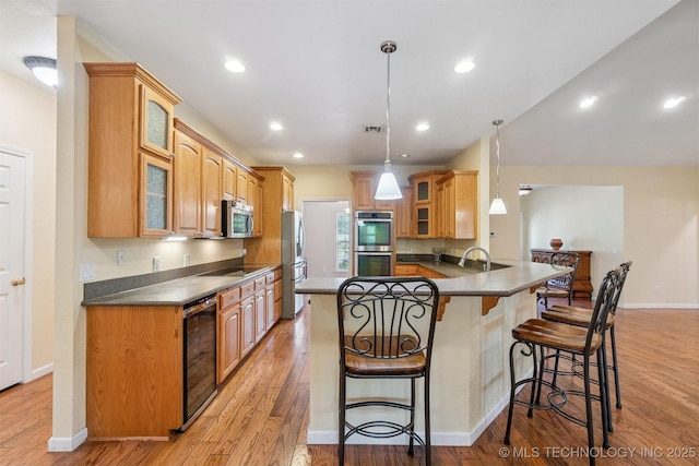 1701 N Skinner Ave, Drumright, OK 74030 - kitchen with wine cooler, stainless steel appliances, a kitchen breakfast bar, a peninsula, and dark countertops