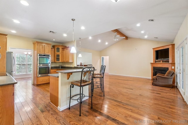 1701 N Skinner Ave, Drumright, OK 74030 - kitchen featuring stainless steel appliances, a kitchen breakfast bar, light wood-style floors, dark countertops, and a peninsula
