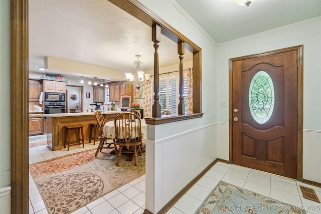 1605 N Skinner Ave, Drumright, OK 74030 - entryway with a chandelier, light tile patterned flooring, wainscoting, and crown molding