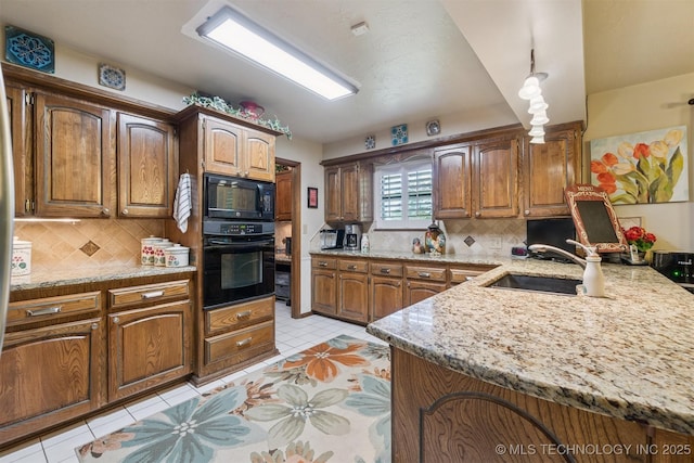 1605 N Skinner Ave, Drumright, OK 74030 - kitchen featuring black appliances, light tile patterned flooring, decorative backsplash, and a peninsula
