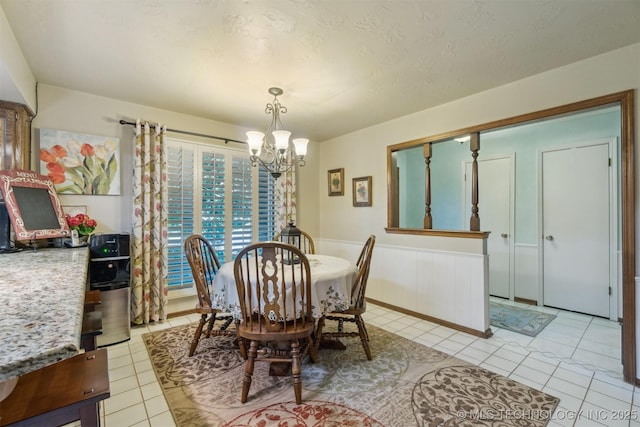 1605 N Skinner Ave, Drumright, OK 74030 - dining area with a chandelier, light tile patterned floors, and wainscoting