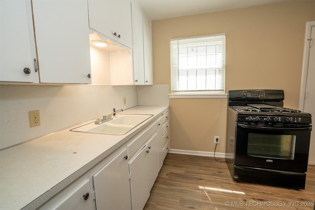 1504 E 51st St, Tulsa, OK 74126 - kitchen featuring black gas range oven, white cabinets, light wood-style floors, and light countertops