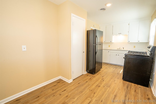1504 E 51st St, Tulsa, OK 74126 - kitchen with black appliances, light wood finished floors, white cabinets, light countertops, and recessed lighting