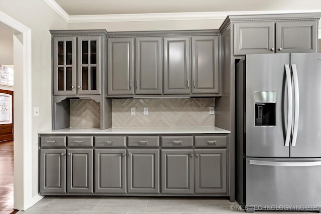 4207 S 69th W Ave, Tulsa, OK 74107 - kitchen featuring stainless steel refrigerator with ice dispenser, gray cabinets, glass insert cabinets, crown molding, and tasteful backsplash