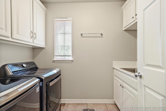 4207 S 69th W Ave, Tulsa, OK 74107 - washroom featuring independent washer and dryer, cabinet space, and light tile patterned floors