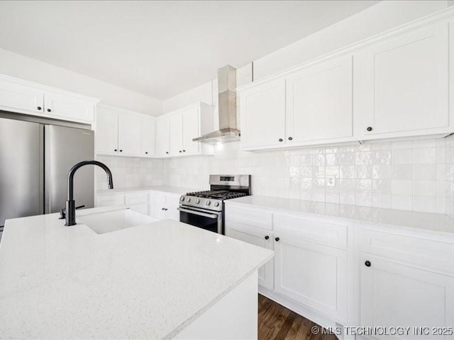 402 E Patti Page Blvd, Claremore, OK 74017 - kitchen with wall chimney range hood, stainless steel appliances, white cabinets, decorative backsplash, and dark wood-style flooring