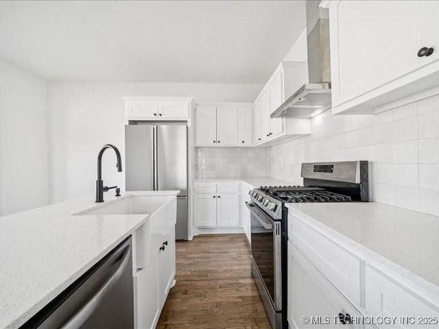 402 E Patti Page Blvd, Claremore, OK 74017 - kitchen with stainless steel appliances, wall chimney exhaust hood, white cabinetry, dark wood finished floors, and tasteful backsplash