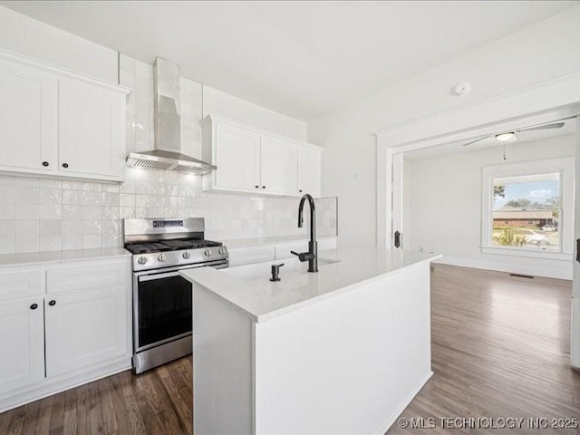 402 E Patti Page Blvd, Claremore, OK 74017 - kitchen featuring stainless steel gas range, wall chimney exhaust hood, dark wood finished floors, light countertops, and decorative backsplash