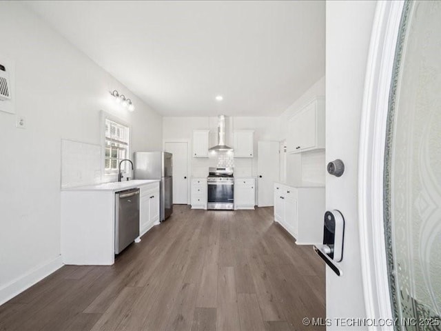 402 E Patti Page Blvd, Claremore, OK 74017 - kitchen with stainless steel appliances, dark wood-style floors, wall chimney range hood, white cabinetry, and recessed lighting