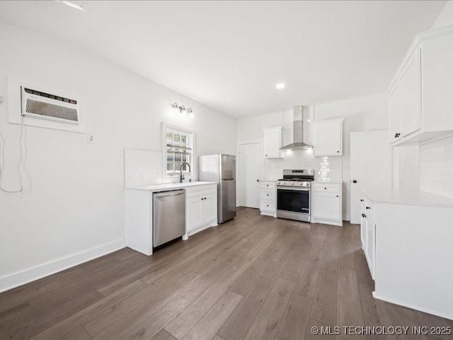 402 E Patti Page Blvd, Claremore, OK 74017 - kitchen featuring stainless steel appliances, wall chimney exhaust hood, wood finished floors, light countertops, and white cabinets