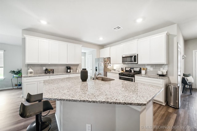 7117 E 154th Pl S, Bixby, OK 74008 - kitchen featuring stainless steel appliances, dark wood finished floors, backsplash, a kitchen breakfast bar, and an island with sink