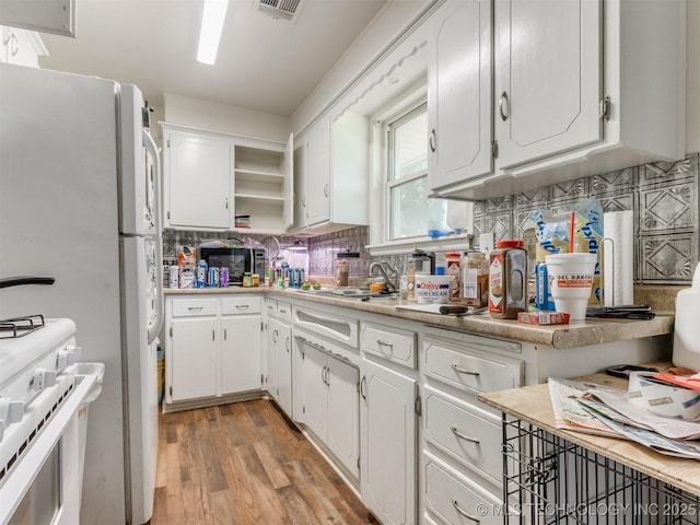 6330 Norman Ave, Oklahoma City, OK 73122 - kitchen featuring white appliances, white cabinetry, decorative backsplash, and light countertops