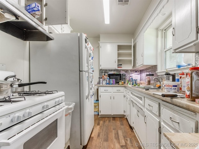 6330 Norman Ave, Oklahoma City, OK 73122 - kitchen with white gas range oven, open shelves, light wood-style flooring, white cabinets, and light countertops