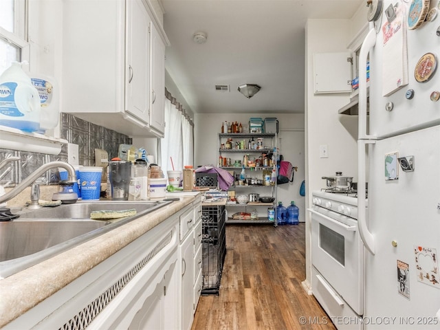 6330 Norman Ave, Oklahoma City, OK 73122 - kitchen featuring white appliances, white cabinets, light countertops, and wood finished floors