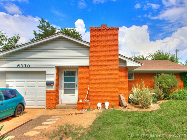 6330 Norman Ave, Oklahoma City, OK 73122 - view of front facade featuring a chimney, a garage, brick siding, and a front yard
