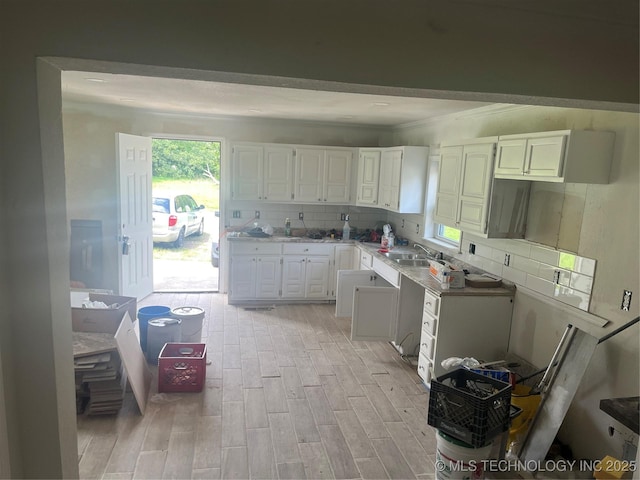 18321 S 103rd W Ave, Sapulpa, OK 74066 - kitchen with white cabinets, light wood finished floors, backsplash, ornamental molding, and light countertops