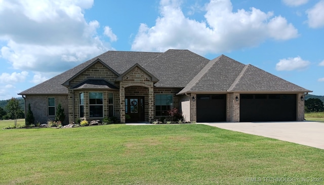 23708 Wolf Crest Way, Wister, OK 74966 - french country home with an attached garage, driveway, a front yard, brick siding, and a shingled roof