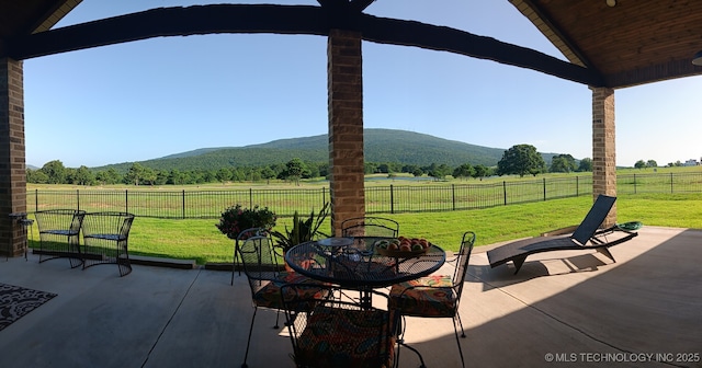 23708 Wolf Crest Way, Wister, OK 74966 - fenced backyard with a view of countryside, a patio area, a mountain view, and outdoor dining space
