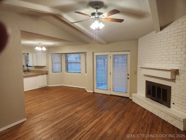 1669 S Pine Ave W, Broken Arrow, OK 74012 - unfurnished living room featuring a textured ceiling, wood finished floors, a fireplace, ceiling fan, and a chandelier