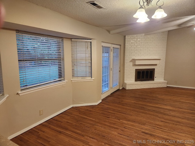 1669 S Pine Ave W, Broken Arrow, OK 74012 - unfurnished living room featuring a textured ceiling, wood finished floors, a chandelier, and a brick fireplace
