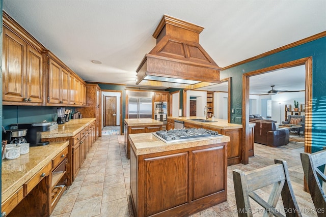 4704 W 88th St, Tulsa, OK 74132 - kitchen with built in appliances, a center island, light countertops, ornamental molding, and brown cabinetry