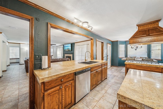4704 W 88th St, Tulsa, OK 74132 - kitchen featuring dishwasher, tile countertops, light tile patterned floors, ornamental molding, and a warm lit fireplace