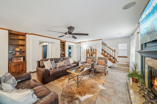 4704 W 88th St, Tulsa, OK 74132 - living room featuring a lit fireplace, ceiling fan, stairs, built in features, and ornamental molding
