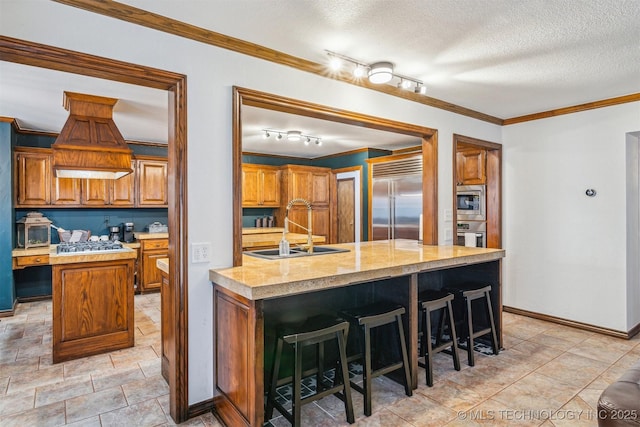 4704 W 88th St, Tulsa, OK 74132 - kitchen featuring built in appliances, a center island, light countertops, ornamental molding, and brown cabinetry