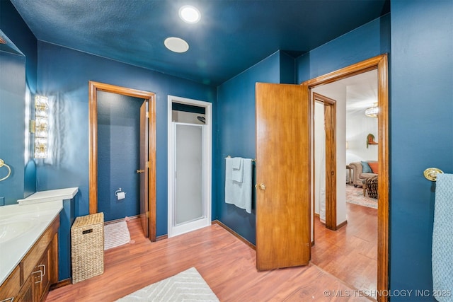 4704 W 88th St, Tulsa, OK 74132 - bathroom featuring vanity, wood finished floors, and a stall shower