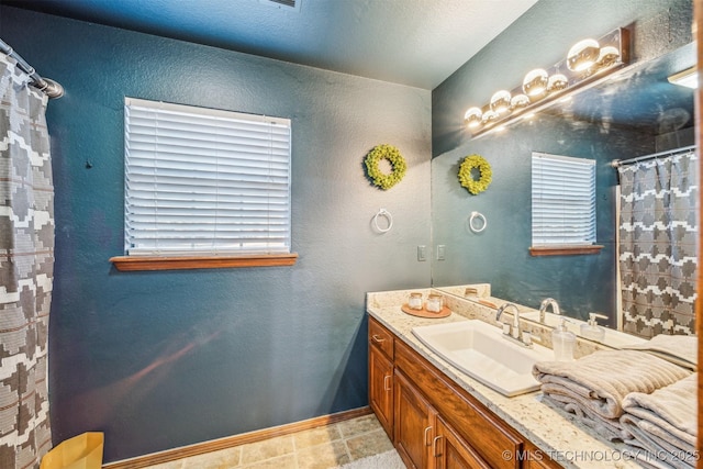 4704 W 88th St, Tulsa, OK 74132 - full bathroom with vanity, a shower with curtain, a textured wall, and plenty of natural light