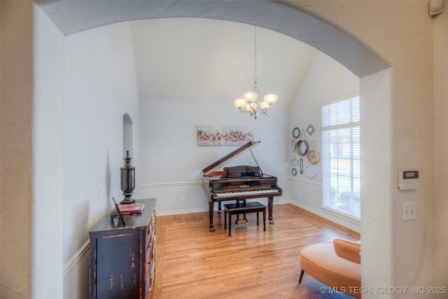 8414 E 99th Pl, Tulsa, OK 74133 - sitting room featuring arched walkways, light wood-type flooring, lofted ceiling, and a chandelier