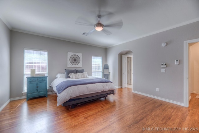8414 E 99th Pl, Tulsa, OK 74133 - bedroom with arched walkways, ornamental molding, multiple windows, light wood-style flooring, and a ceiling fan